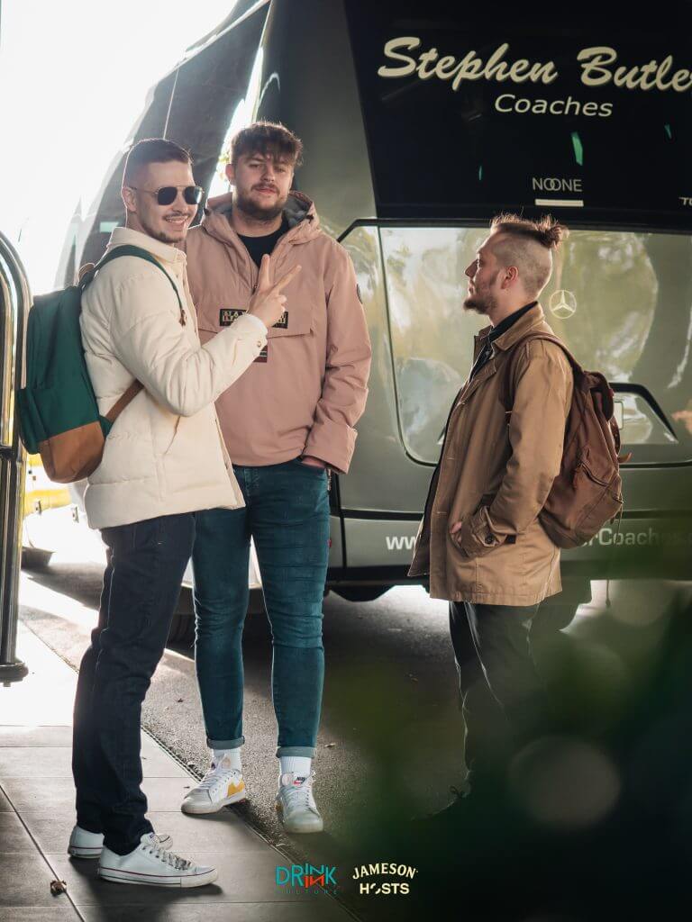 Photo of three men standing in front of a bus.