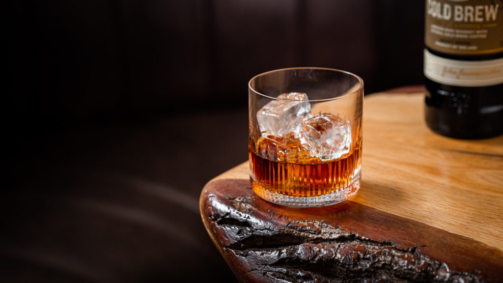 Photo of Old Fashioned cocktail on a wooden table.
